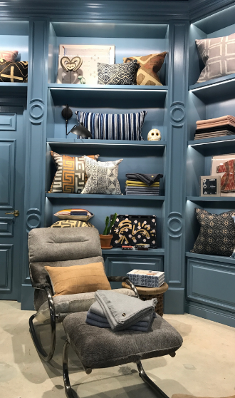 A beautifully staged showroom with a custom bookcase and designer chair.