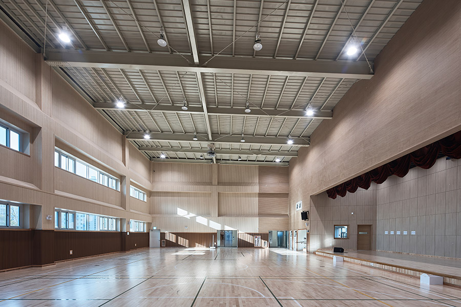 The interior of a modern, clean, school gymnasium.